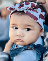 Little girl is wearing a soft baby headband for little girls from By Bella Boutique.